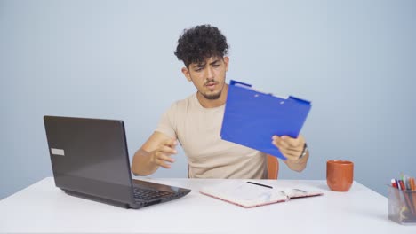 Man-working-on-laptop-throws-files-angrily.